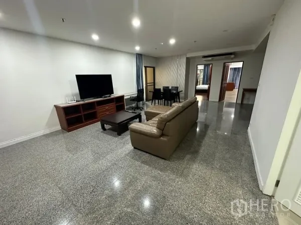 คอนโด ให้เช่าในWatthana, Bangkok - ห้องนั่งเล่นกว้าง โซฟาหนัง ชั้นวางทีวี ชุดโต๊ะทานข้าว และพื้นหินเงางาม