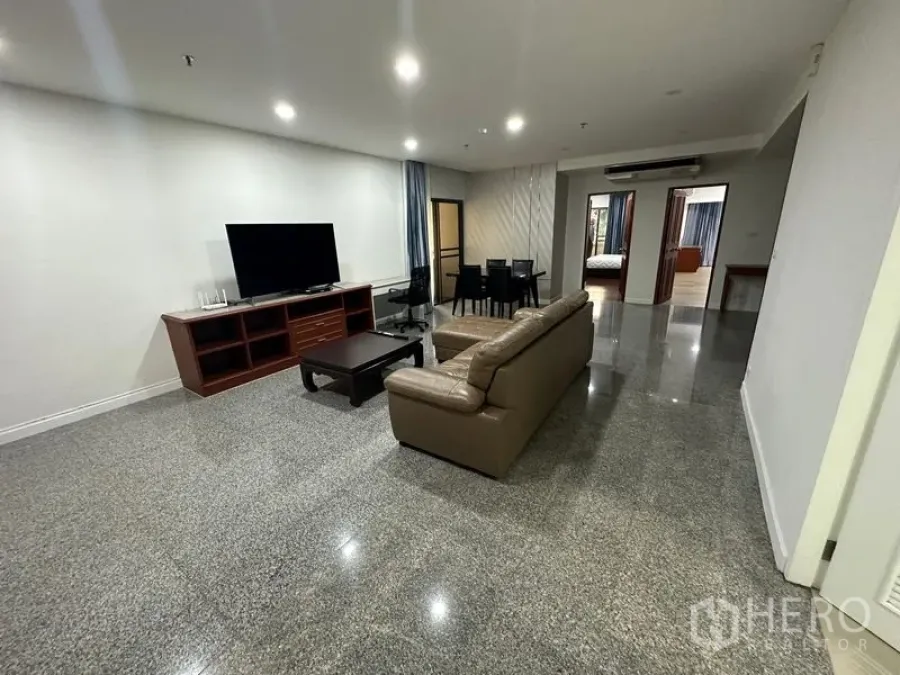 คอนโด ให้เช่าในWatthana, Bangkok - ห้องนั่งเล่นกว้าง โซฟาหนัง ชั้นวางทีวี ชุดโต๊ะทานข้าว และพื้นหินเงางาม