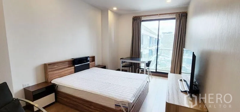 Condominium for rent - Spacious master bedroom with king bed, TV cabinet and a large window overlooking the skyline.