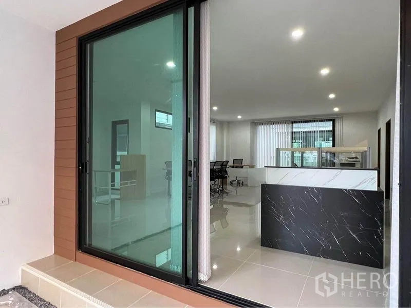 Home Office for rent in Bang Phli, Samut Prakan - Sliding glass door opening to bright lobby with marble reception counter and office area.