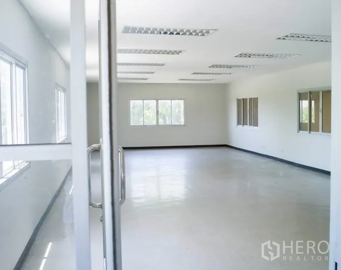 工厂 出租在Pathum Thani - 采光充足的办公室，白色墙面与大窗户，天花板日光灯。