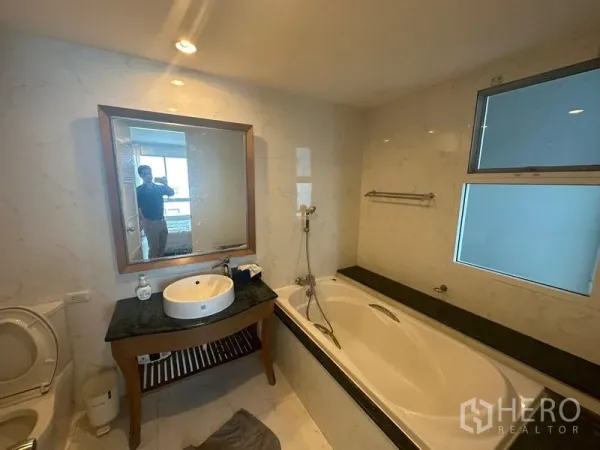 คอนโด ให้เช่า - ห้องน้ำปูกระเบื้องลายหินอ่อน มีอ่างอาบน้ำ เคาน์เตอร์อ่างล้างหน้า และหน้าต่าง