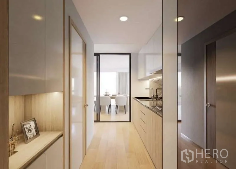 Condominium for rent in Huai Khwang, Bangkok - Galley kitchen corridor with built-in cabinets leading to the dining room.