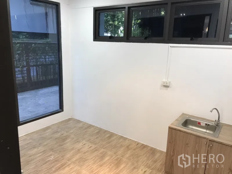 零售空间 出租在Watthana, Bangkok - 带水槽的小型茶水间/后场，设有窗户与木纹柜体。