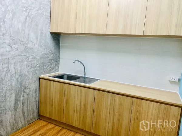 办公空间 出租在Bang Rak, Bangkok - 内置茶水间，配备水槽、木质柜体与白色瓷砖背墙