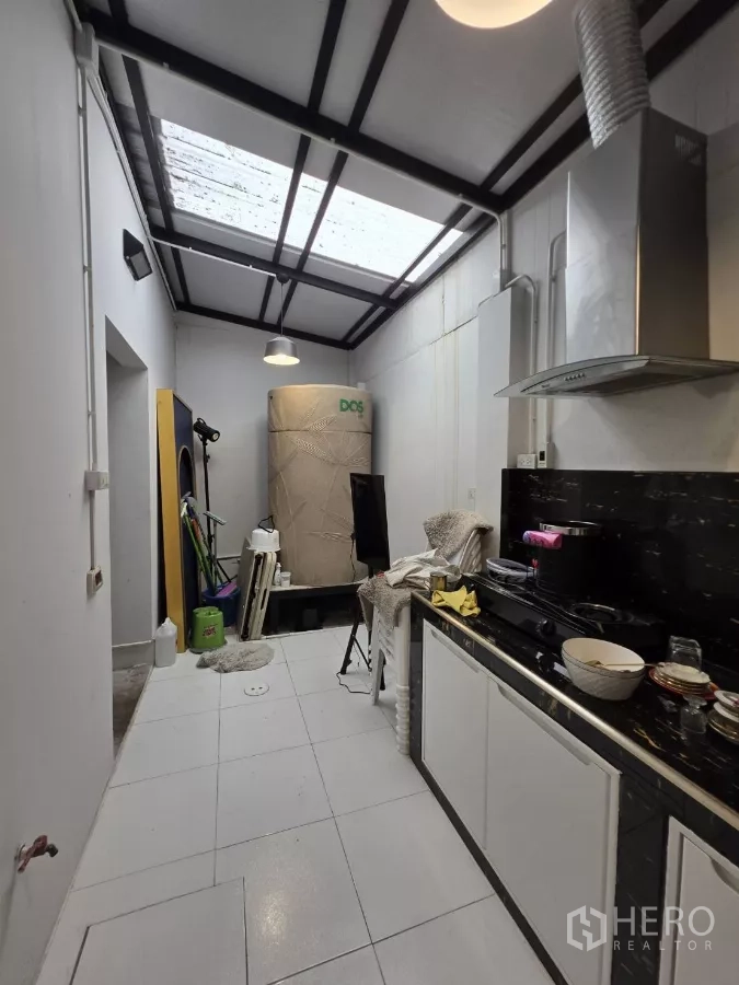Home Office for rent in Pak Kret, Nonthaburi - Galley kitchen with skylight roof, range hood and black stone countertop with cabinetry.