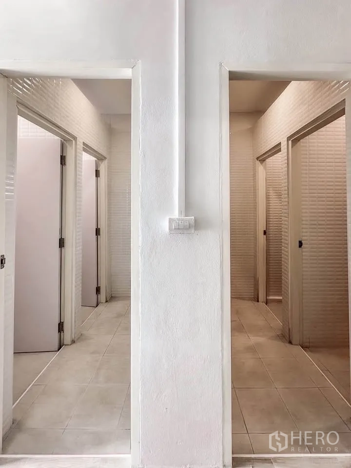联排别墅 for sale in Wang Thonglang, Bangkok - 走廊两侧多间卫浴门，白色纹理墙面。