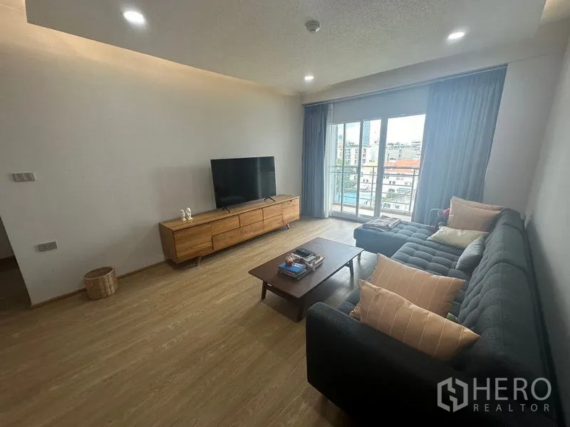 Condominium for rent - Bright lounge with sectional sofa, TV and sliding doors to the balcony.