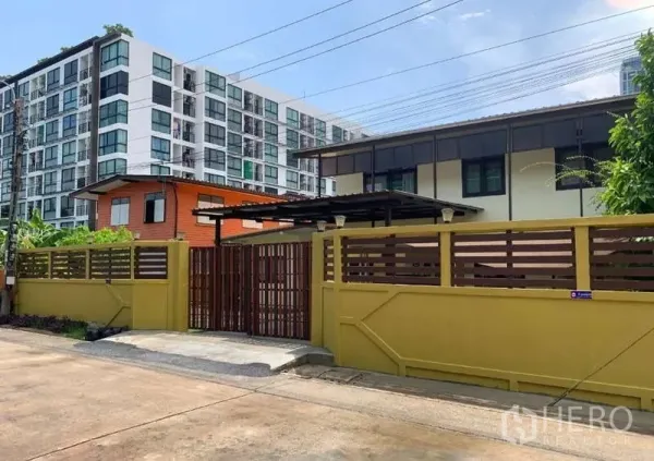 独立式住宅 出租或出售在Phra Khanong, Bangkok - 带高隐私围墙和木门的独栋住宅，旁有现代公寓楼，位于帕卡农。