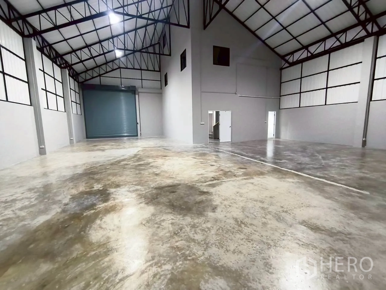 仓库 for rent in Mueang Nonthaburi, Nonthaburi - 开阔仓储区，带卷帘门、多扇通道门与高屋顶。