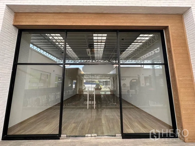 零售空间 出租 - 落地玻璃店面，木质装饰边框与室内木纹地面。