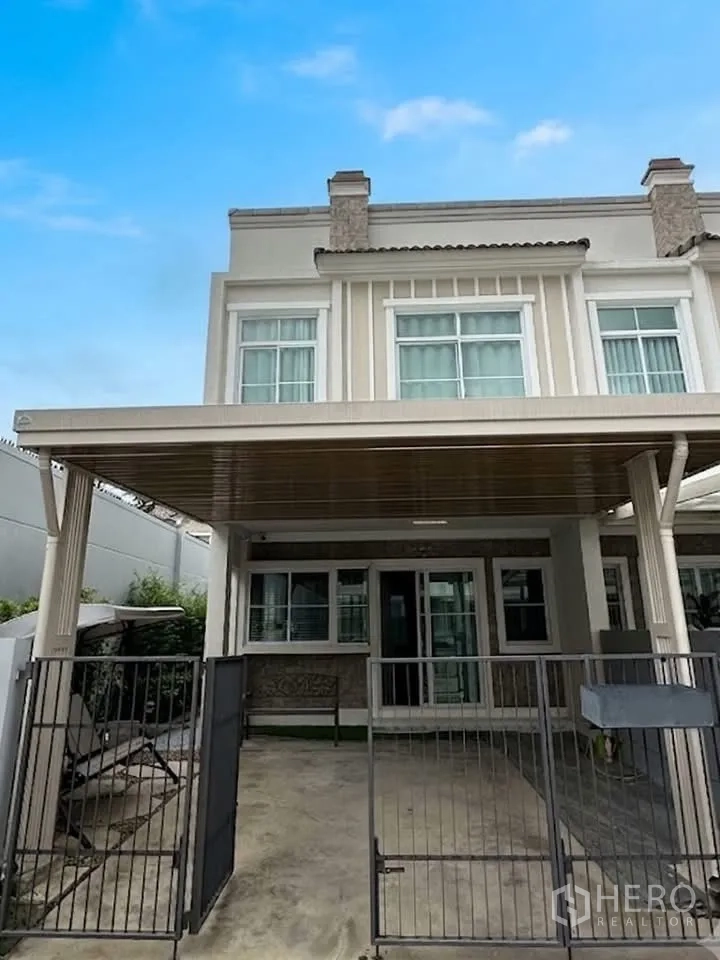 联排别墅 for rent in Prawet, Bangkok - 联排别墅两层外立面，带大门与遮雨车位。