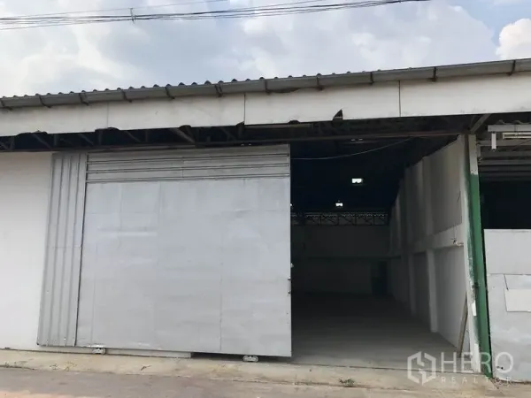 货栈 出租或出售在Khlong Luang, Pathum Thani - 仓库外立面，宽大金属滑门与遮檐装卸入口