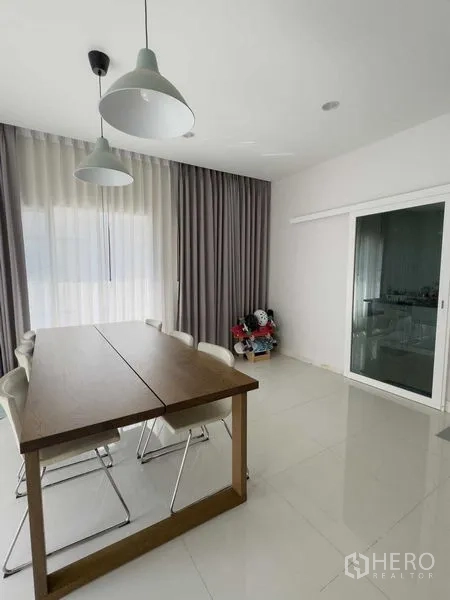 บ้าน ให้เช่าหรือขายในBang Khen, Bangkok - ห้องทานอาหาร โต๊ะไม้ เก้าอี้หกตัว โคมไฟแขวน และประตูกระจกบานเลื่อน