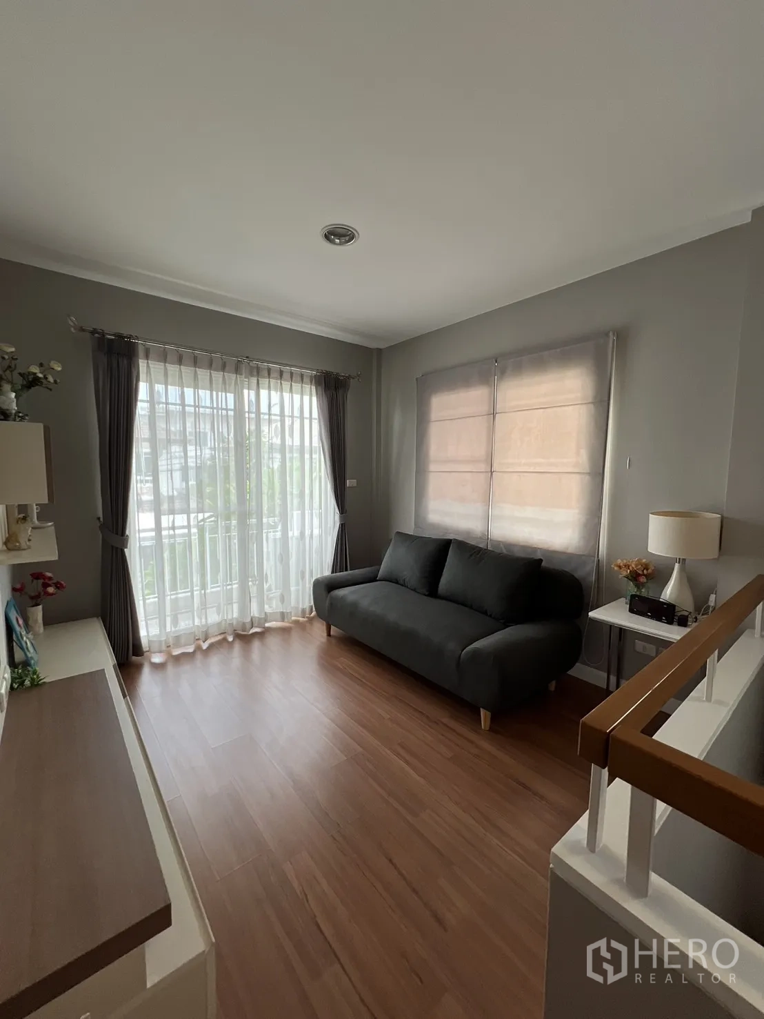 Detached House for rent in Bang Kapi, Bangkok - Another angle of the upstairs lounge with wood flooring and curtains.