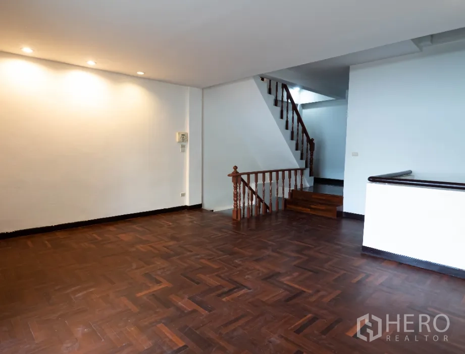 ทาวน์เฮาส์ ให้เช่าในKhlong Toei, Bangkok - ห้องนั่งเล่นกว้างพื้นปาเกต์ ไฟดาวน์ไลท์ และบันไดขึ้นชั้นบน