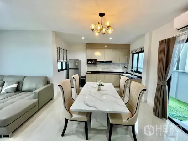 Townhouse for rent in Bang Phli, Samut Prakan - Open kitchen and dining with U-shaped counters, stone backsplash and large windows.