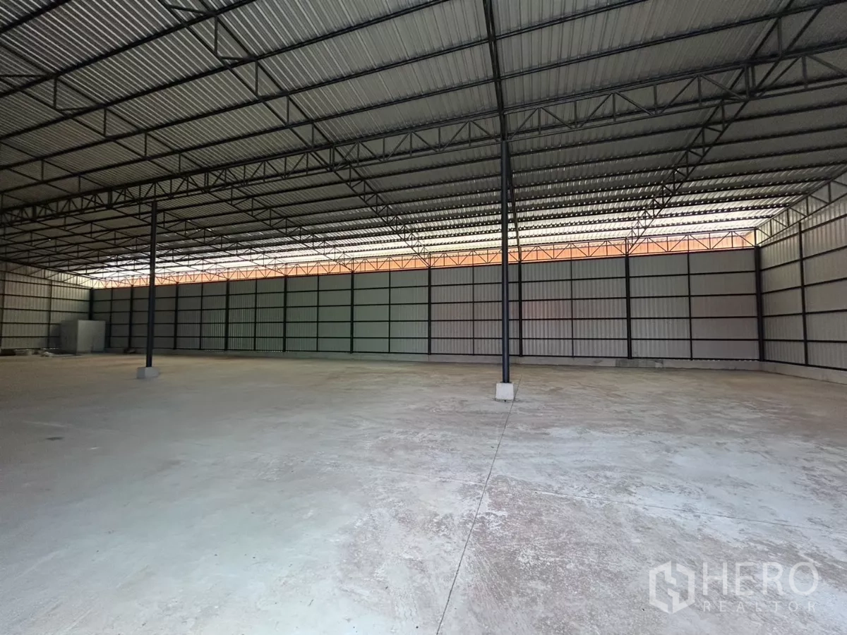 Warehouse for rent in Khlong Toei, Bangkok - Clear-span warehouse interior showing steel columns, ribbed metal roof and open floor area.