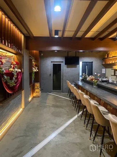 店屋 出租 - 酒吧休闲区另一视角，展示吧台座位与背光陈列。