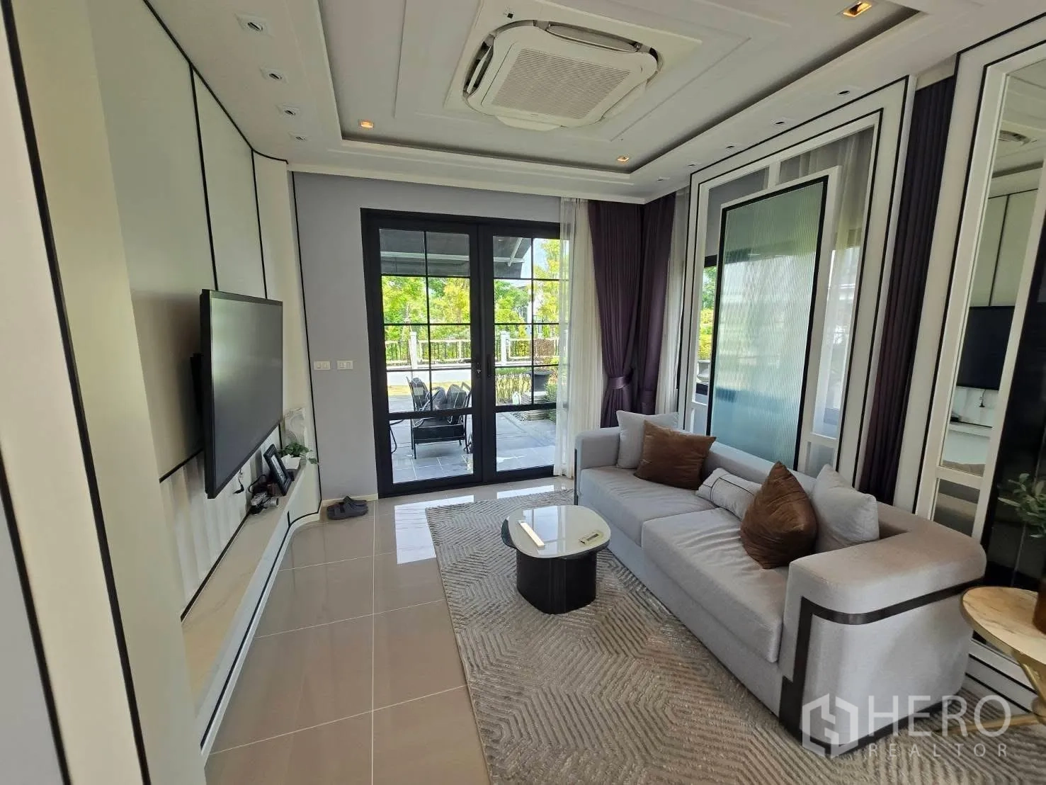 Semi-detached House for rent in Bang Phli, Samut Prakan - Cozy lounge with sectional sofa facing glass doors to outdoor seating.