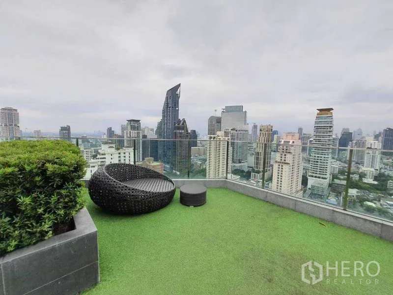 公寓 出售在Watthana, Bangkok - 屋顶花园配圆形躺椅与玻璃护栏，面向曼谷天际线。