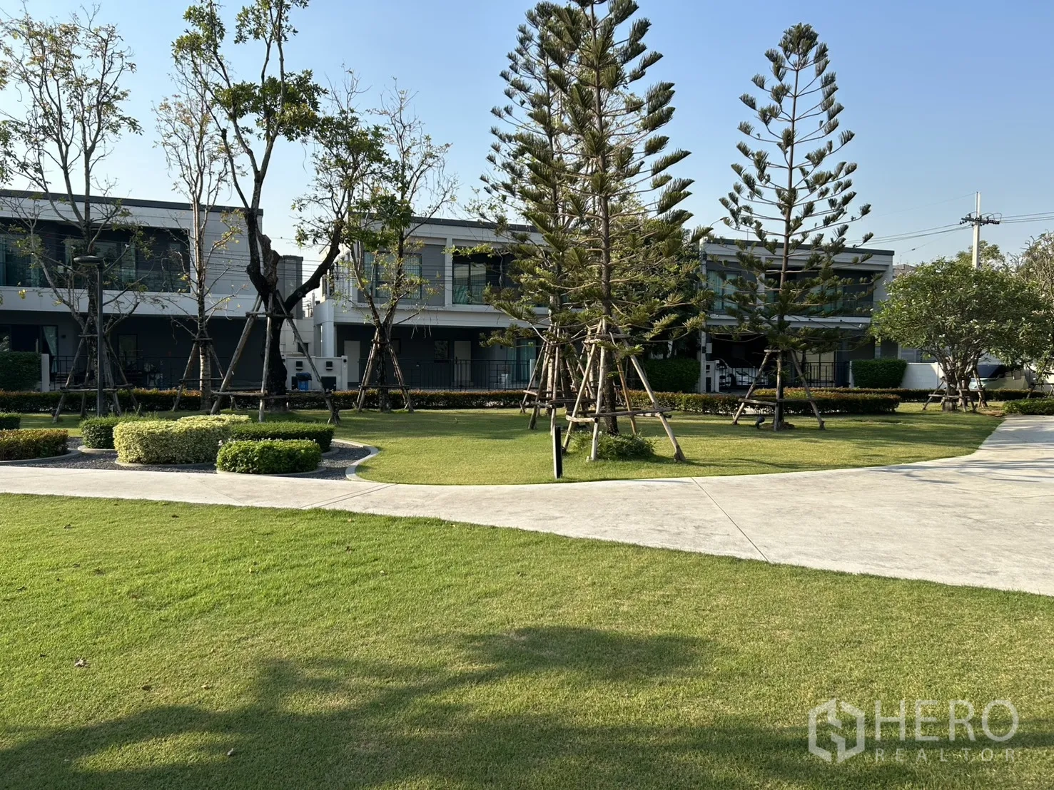 Detached House for rent in Bang Phli, Samut Prakan - Landscaped communal green lawn with walking paths and tall trees.
