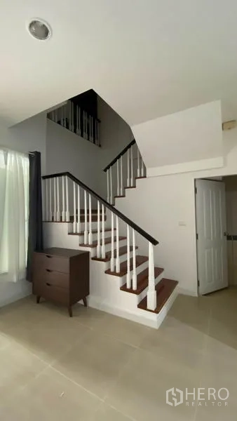 Townhouse for rent in Wang Thonglang, Bangkok - Staircase with white balusters leading to the upper floors of the townhouse.