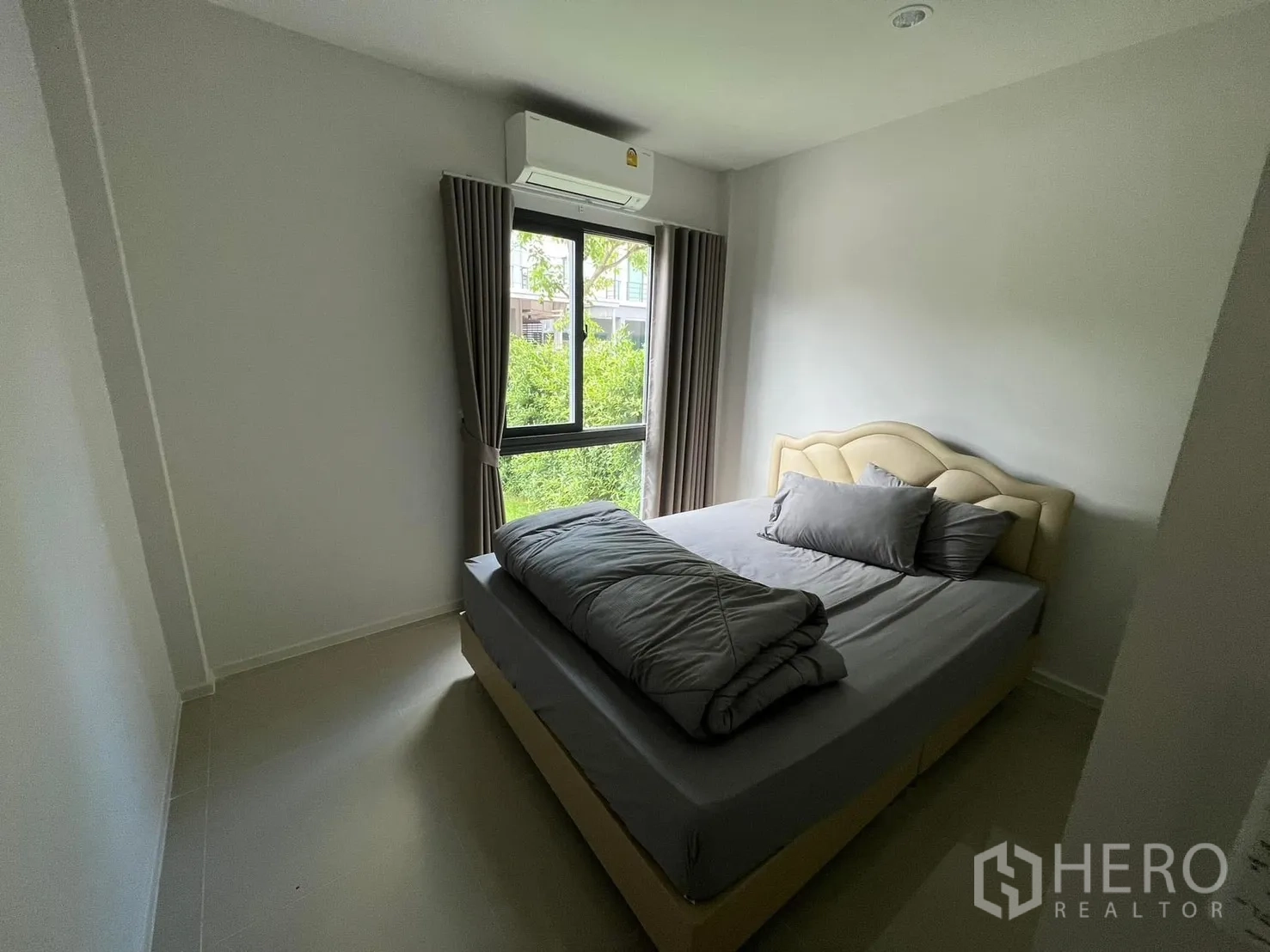 Semi-detached House for rent in Saphan Sung, Bangkok - Cozy bedroom with double bed, air conditioner, and window overlooking greenery.