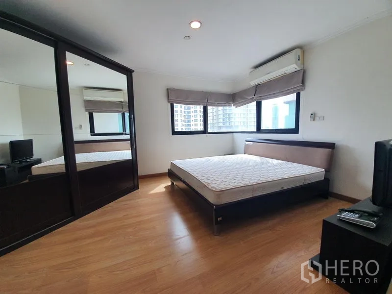 公寓 出租在Sathon, Bangkok - 主卧带转角窗、镜面衣柜、空调与木地板。