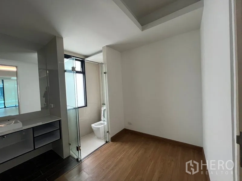ทาวน์เฮาส์ ให้เช่าหรือขายในKhlong Toei, Bangkok - ห้องนอนพื้นไม้เชื่อมต่อห้องน้ำในตัว มีฉากกั้นกระจกและเคาน์เตอร์อ่างล้างหน้า