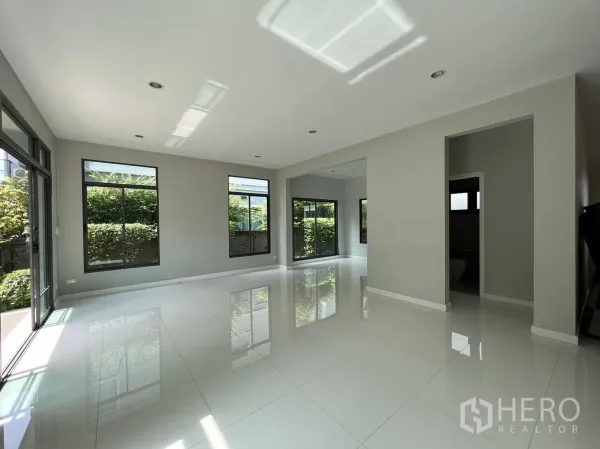 Detached House for sale in Suan Luang, Bangkok - Sunlit ground-floor lounge with garden-facing windows and sliding doors.