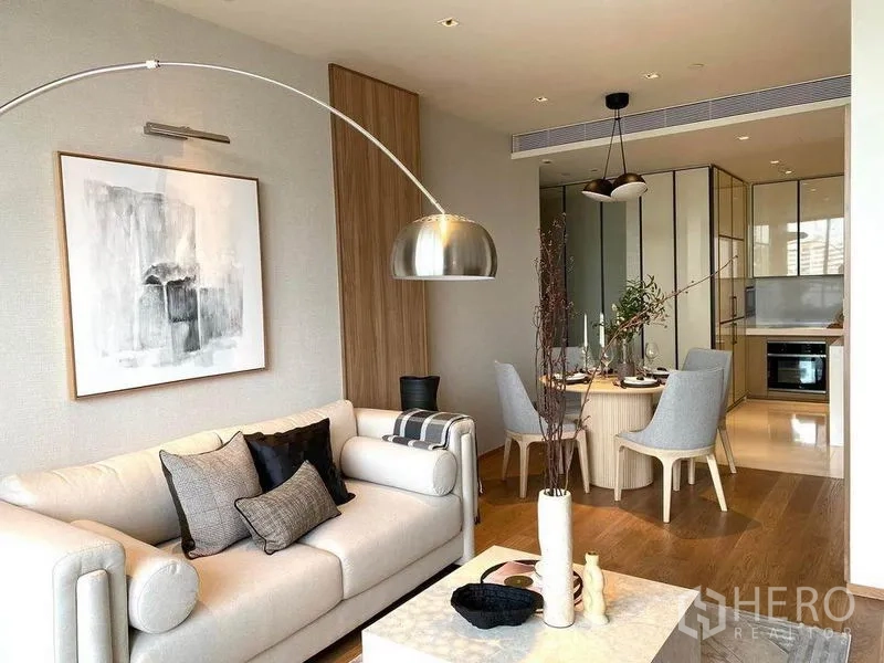 Condominium for rent or sale in Khlong Toei, Bangkok - Sunlit living and dining room with soft neutral decor and contemporary lighting.