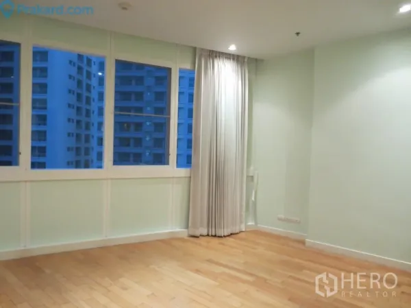 คอนโด ให้เช่าในKhlong Toei, Bangkok - ห้องนอนมุมอาคาร พื้นไม้ หน้าต่างกว้างพร้อมผ้าม่าน มองเห็นตึกสูงรอบด้าน