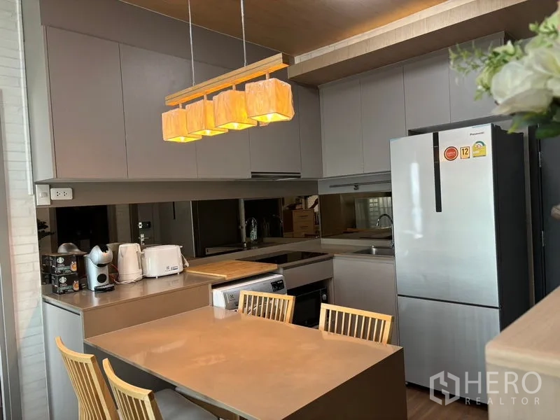 公寓 出租或出售在Phra Khanong, Bangkok - 全配套厨房，双门冰箱、充足橱柜与吊灯餐桌。