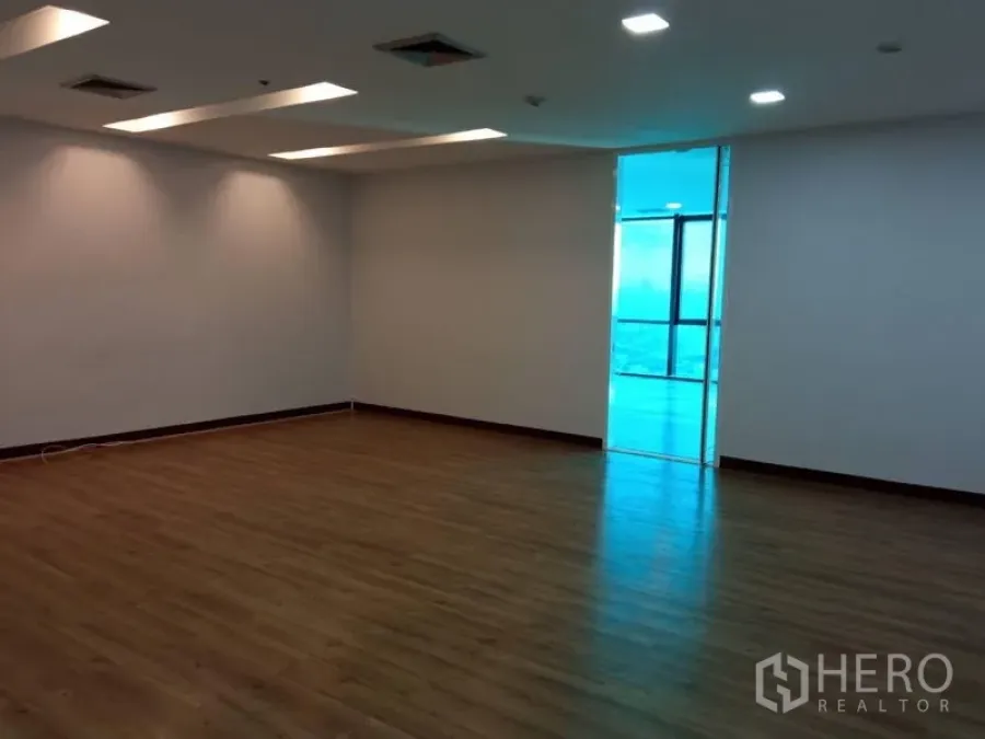 办公空间 出租在Huai Khwang, Bangkok - 宽敞开放式办公室，木地板、天花灯槽照明，通往明亮窗边区。