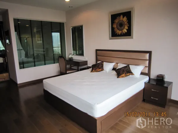 คอนโด ให้เช่าหรือขายในPathum Wan, Bangkok - มุมห้องนอนกว้าง เห็นเตียง โต๊ะหัวเตียง โต๊ะทำงาน และช่องหน้าต่างติดบานมู่ลี่เชื่อมห้องน้ำ