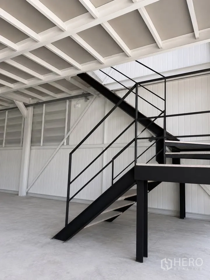 Warehouse for rent in Bang Na, Bangkok - Interior view of warehouse mezzanine with steel staircase and open floor.