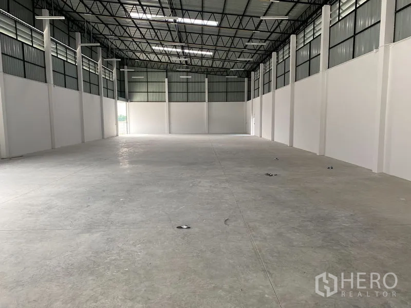 Warehouse for rent or sale in Bang Len, Nakhon Pathom - Long unobstructed warehouse bay with high roof, ventilation panels and smooth concrete slab.