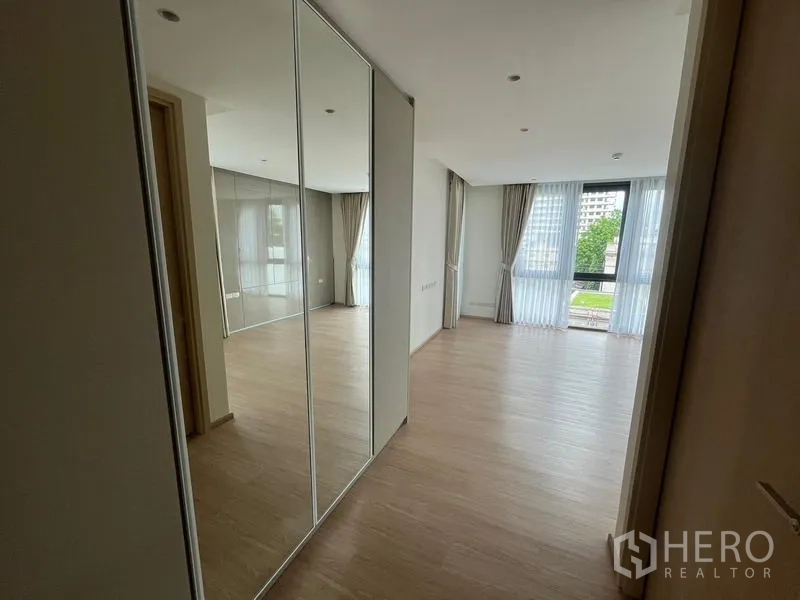 ทาวน์เฮาส์ ให้เช่าในKhlong Toei, Bangkok - ห้องนอนรับแสงพร้อมตู้เสื้อผ้าบานกระจกและหน้าต่างบานใหญ่