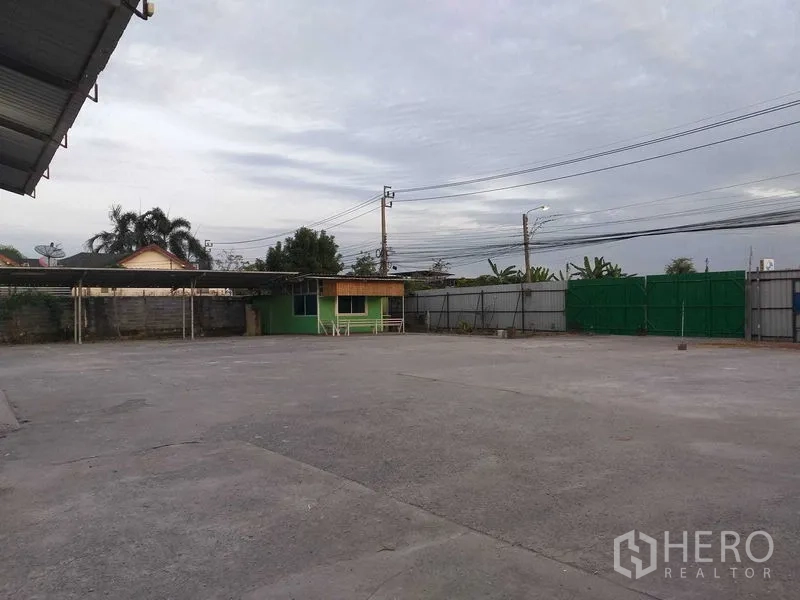 คลังสินค้า ให้เช่าในKhlong Sam Wa, Bangkok - ลานคอนกรีตกว้าง มีป้อมยามและรั้วรอบแน่นหนาริมถนน