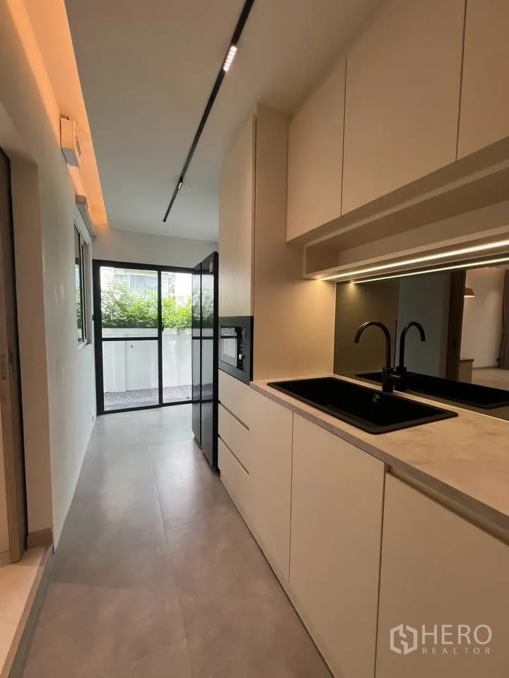 Townhouse for rent in Prawet, Bangkok - Kitchen corridor leading to sliding glass door and patio.