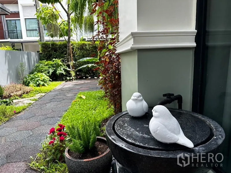 独立式住宅 出租在Prawet, Bangkok - 花园水景特写，白色小鸟装饰与草坪。