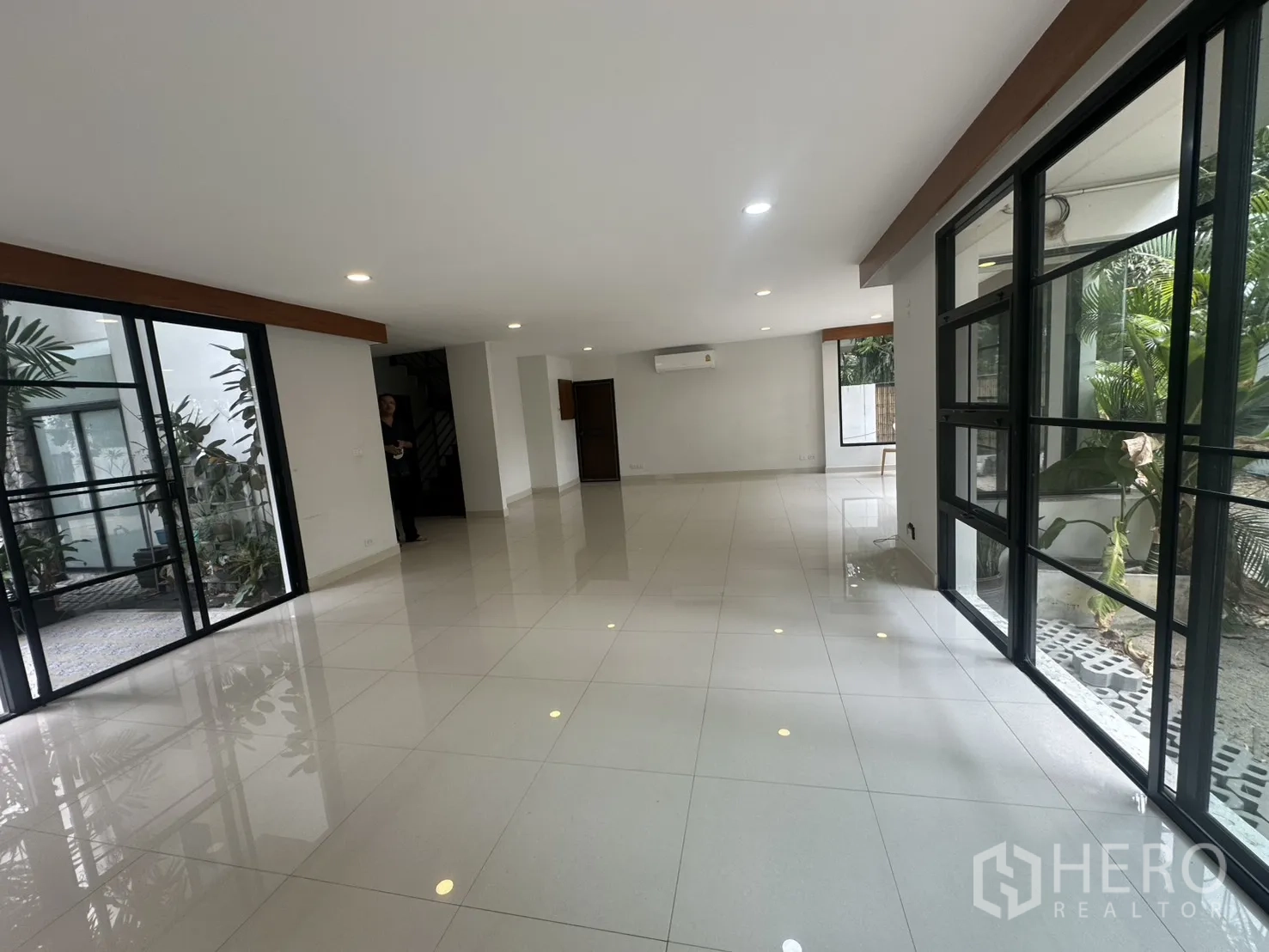 独栋房屋 for rent in Watthana, Bangkok - 开阔起居区，落地推拉门通向庭院与全景窗