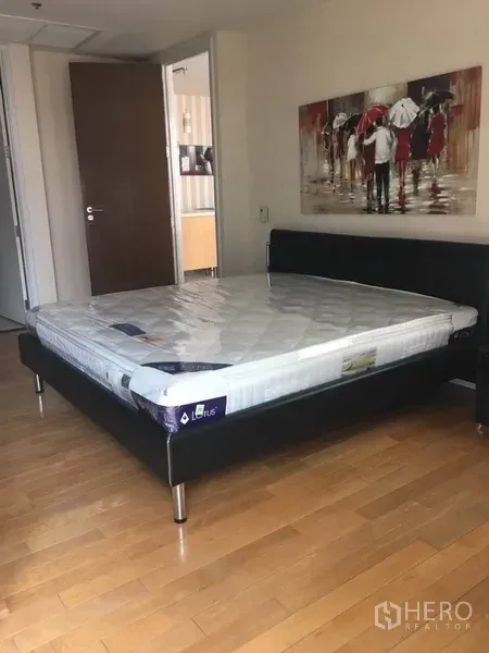 公寓 出租在Bang Rak, Bangkok - 采光明亮的卧室，大床、木地板与现代挂画。