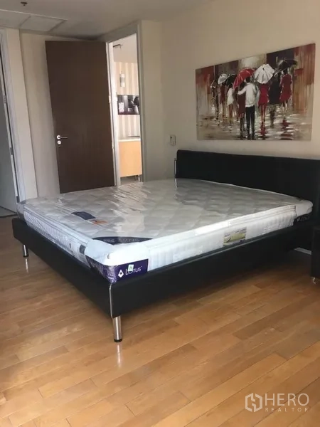 公寓 出租在Bang Rak, Bangkok - 采光明亮的卧室，大床、木地板与现代挂画。