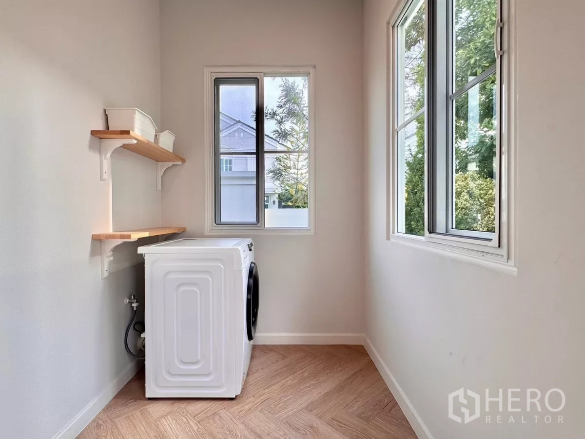 Detached House for rent in Bang Phli, Samut Prakan - Laundry room with washing machine, wall shelves and two windows.