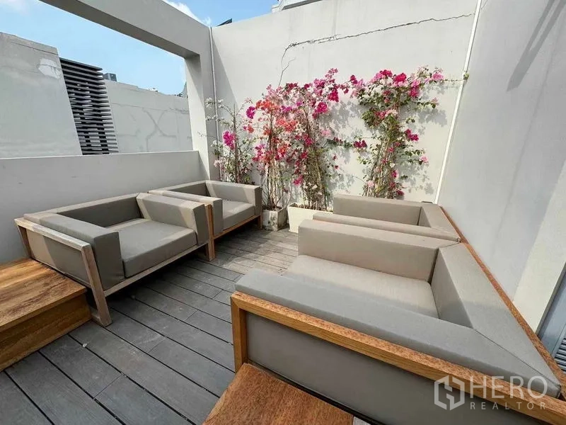 ทาวน์เฮาส์ ให้เช่าในWatthana, Bangkok - เทอเรสดาดฟ้าพร้อมชุดนั่งเล่นกลางแจ้งและดอกเฟื่องฟ้า.