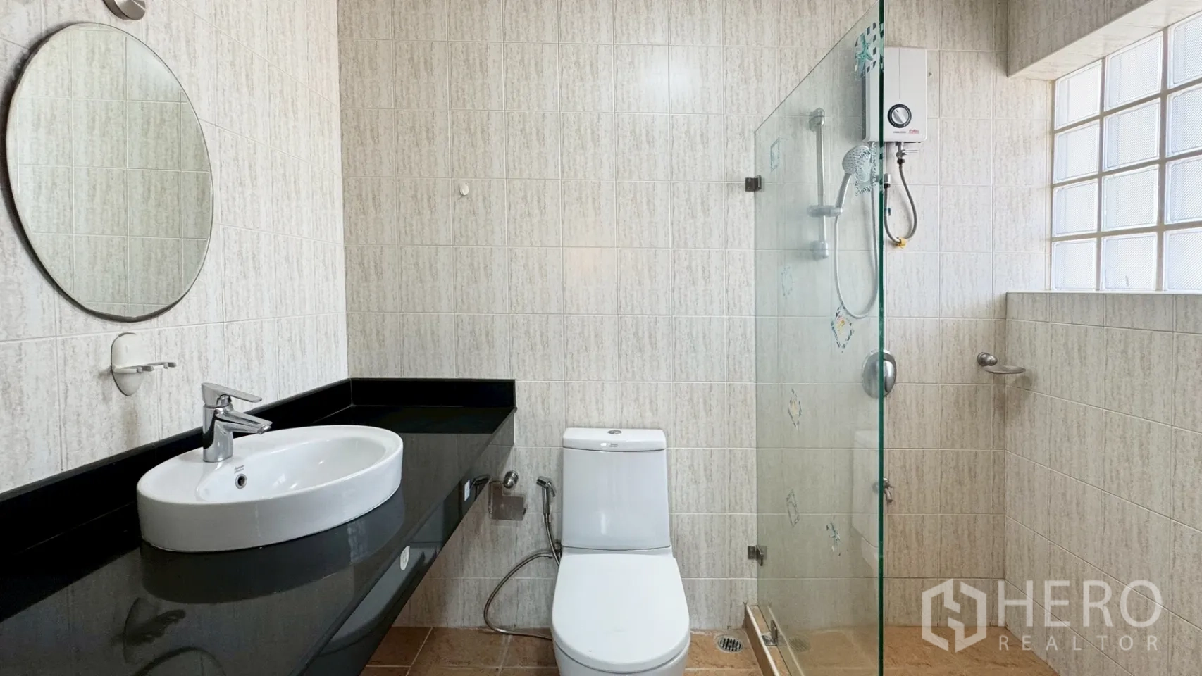 独栋房屋 for rent in Suan Luang, Bangkok - 浴室配玻璃淋浴间、圆镜、黑色台面与坐便器。