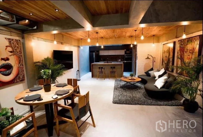 ทาวน์เฮาส์ ให้เช่าในKhlong Toei, Bangkok - โถงนั่งเล่นและทานอาหารแบบโอเพ่นสเปซ โทนคอนกรีตและไม้ มีงานศิลป์และไฟห้อย ต่อเนื่องถึงครัว