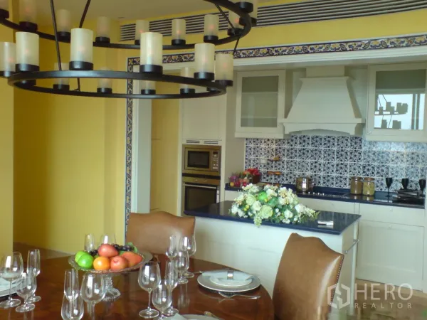 Condominium for rent in Khlong Toei, Bangkok - Open-plan kitchen and dining with blue countertops and decorative tile backsplash.